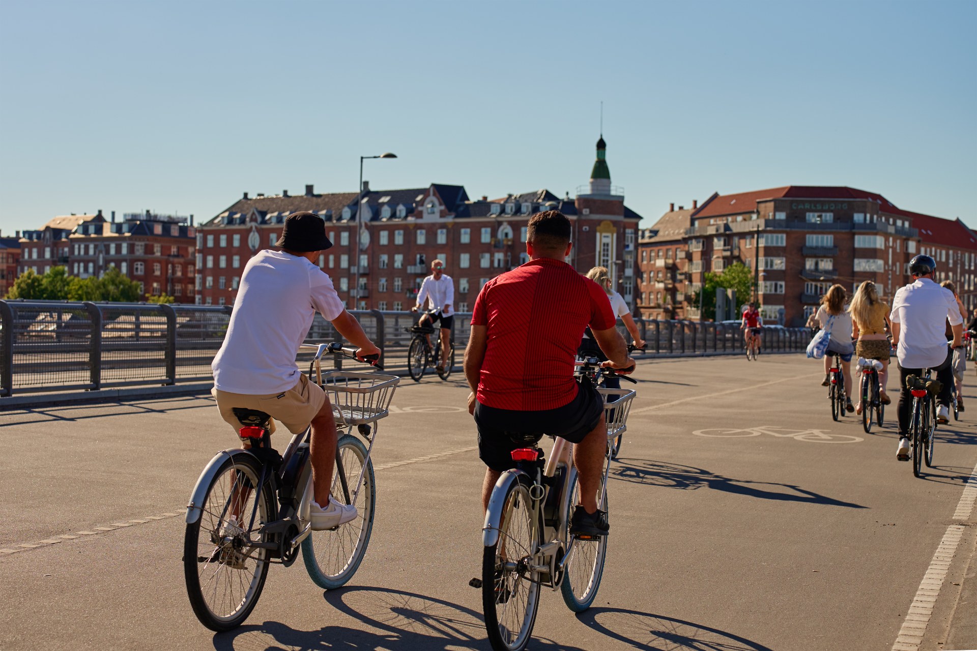 Mladí ľudia jazdia na bicykloch po ulici v Kodani